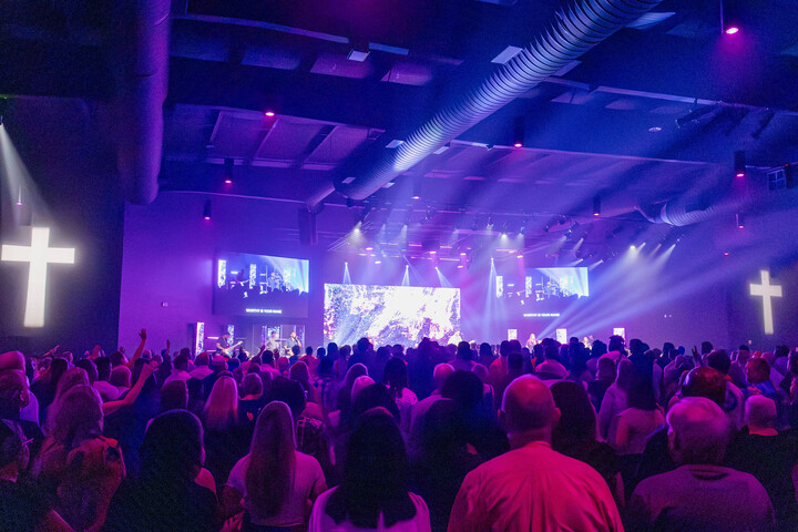 The image showcases a vibrant stage filled with performers and a lively crowd, highlighting a public event at Cornerstone Church Athens. This scene reflects the church's commitment to fostering community engagement through music and worship events.